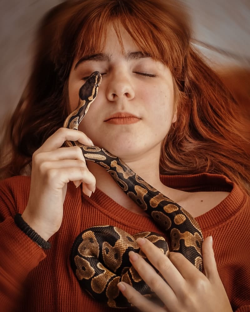 mulher pegando numa cobra mansa
