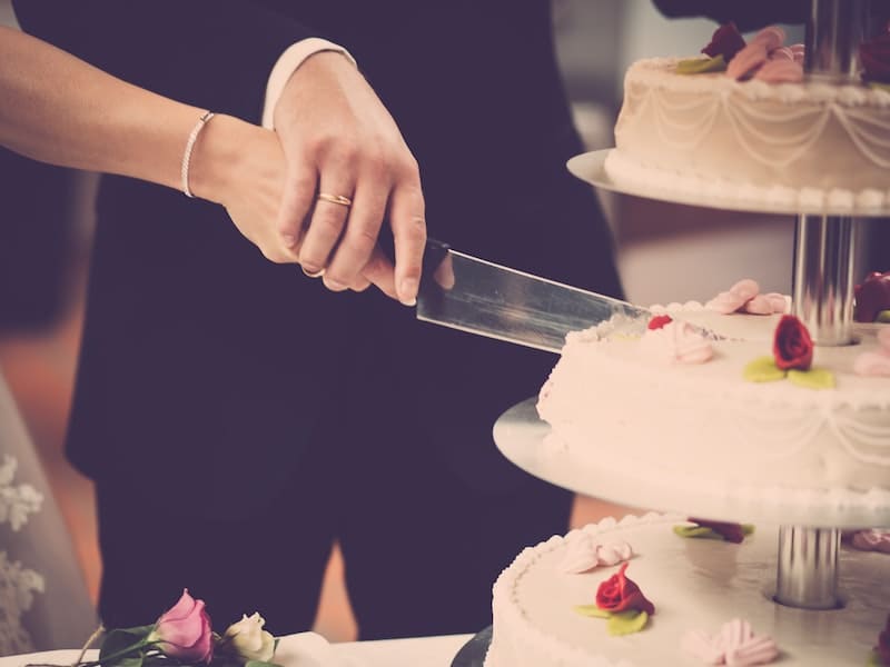 mulher cortando bolo de casamento